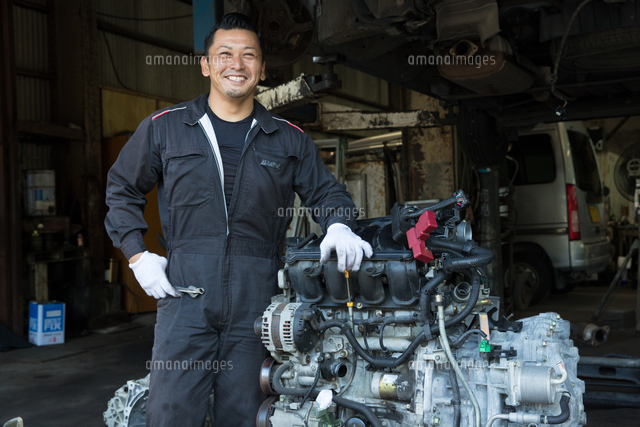 会社代表の写真。車を整備しています。